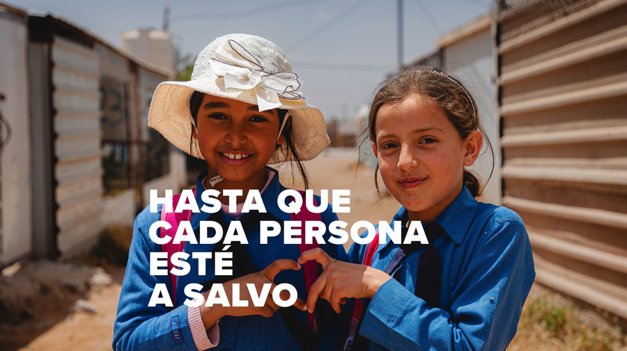 Dos niñas vestidas de azul forman un corazon con sus dedos. Se lee HASTA QUE CADA PERSONA ESTÉ A SALVO