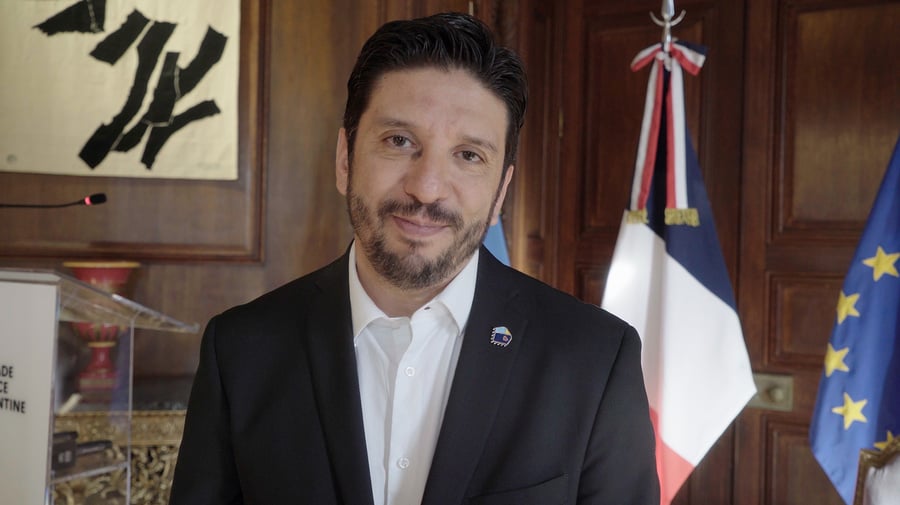Retrato de un hombre con barba que viste camisa blanca y saco negro