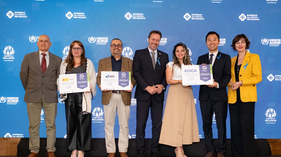 De pie, un grupo de cuatro hombres y tres mujeres con vestimenta formal