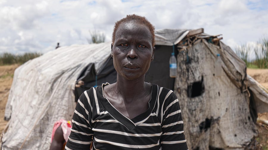 Aduot Wuoi Monjuon, desplazada interna, posa junto a su refugio en Bor, Sudán del Sur, donde se ha desplazado después de que las inundaciones la obligaran a huir de su aldea en el Estado de Jonglei, junto a su familia.