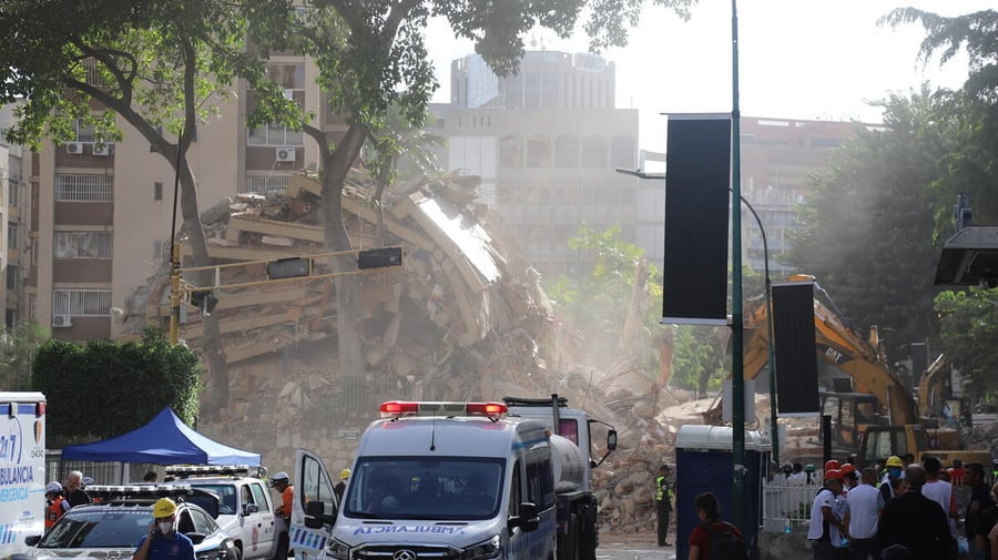 Equipos de búsqueda y rescate trabajan entre los escombros de un edificio derrumbado.