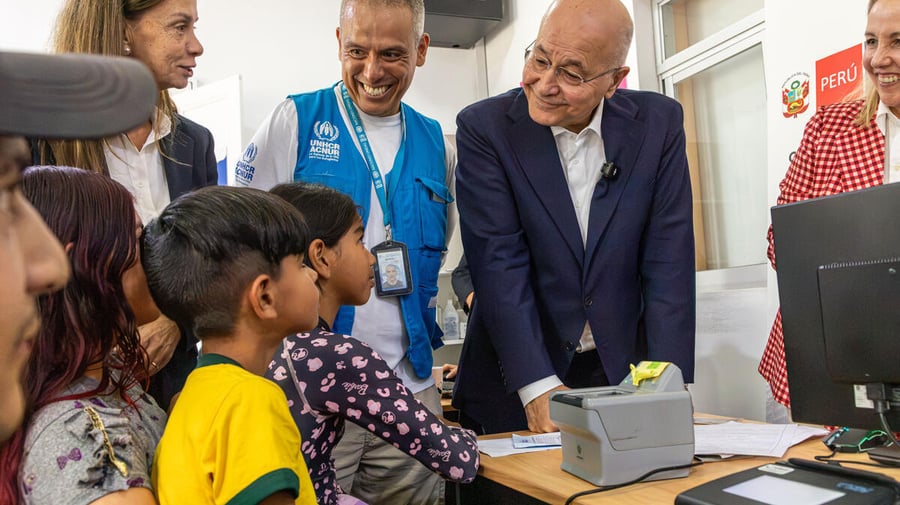 El Alto Comisionado de la ONU para los Refugiados, Barham Salih, y funcionarios de ACNUR hablan con una familia de Venezuela en un centro de protección de Lima, Perú.