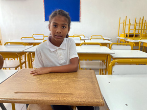Una niña sentada en un pupitre en un salón de clases