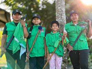 Dos mujeres adultas y dos niñas con los chalecos verdes de Guardia Indígena y los bastones de autoridad.