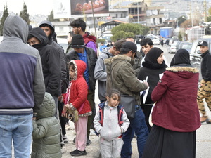 Un grupo de personas se reúnen en el paso fronterizo de Masnaa, en el Líbano, mientras espera cruzar a Siria para escapar de los bombardeos israelíes en curso y de las órdenes de evacuación.
