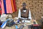 El refugiado camerunés Issa Hassane, de 25 años, gana dinero reparando...