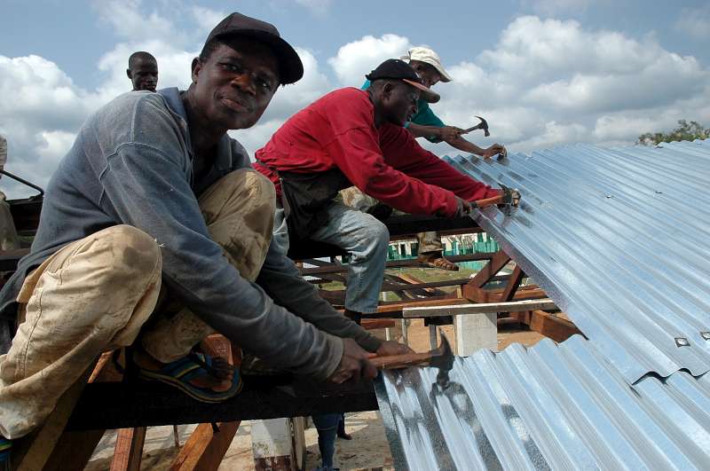 A través de un proyecto especial de empoderamiento de la comunidad, estas personas desplazadas construyen una escuela y un techo para el mercado en la ciudad de Gbarlatuah, condado de Bong, Liberia. 
