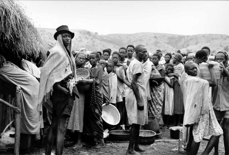 Conforme se acercaba el final del colonialismo en la década de 1960, surgieron conflictos en muchas partes de África, con inclusión de aquel que estalló en Ruanda. Este grupo de personas originarias de ese país aguarda la distribución de alimentos en un centro de refugiados en el Valle de Oruchinga, en Uganda.