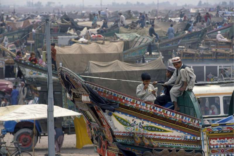 En una parada cerca de la ciudad pakistaní de Peshawar, personas afganas refugiadas se preparan para volver a casa.