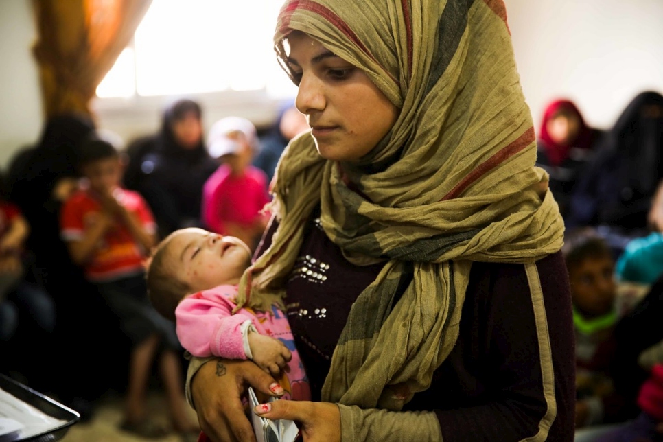 Samira, una madre siria, visita un centro comunitario de ACNUR en Alepo para solicitar asistencia jurídica en el registro del nacimiento de su hijo.