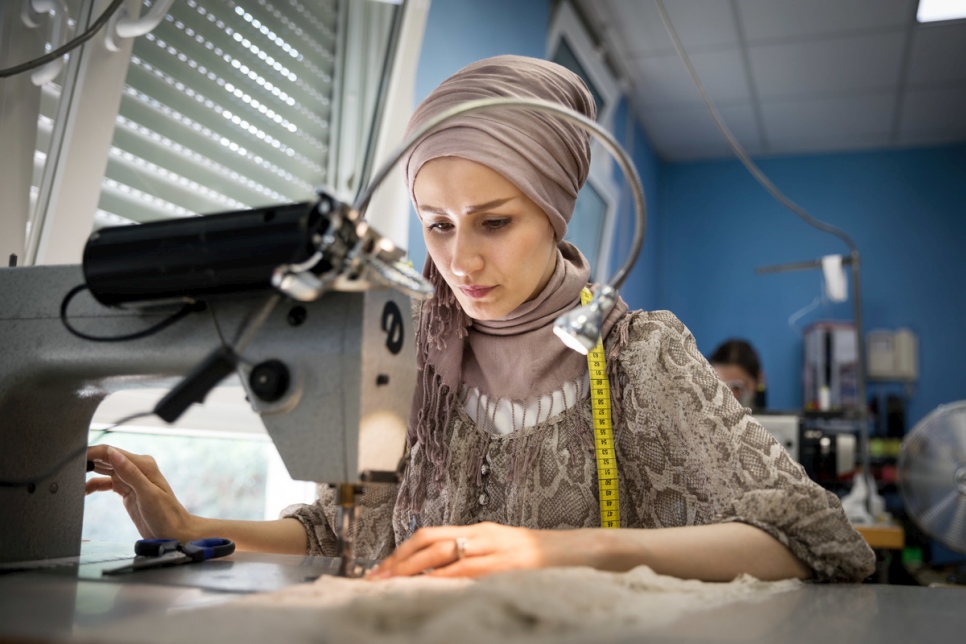Reyhane, que huyó de Afganistán, cosiendo en el taller.