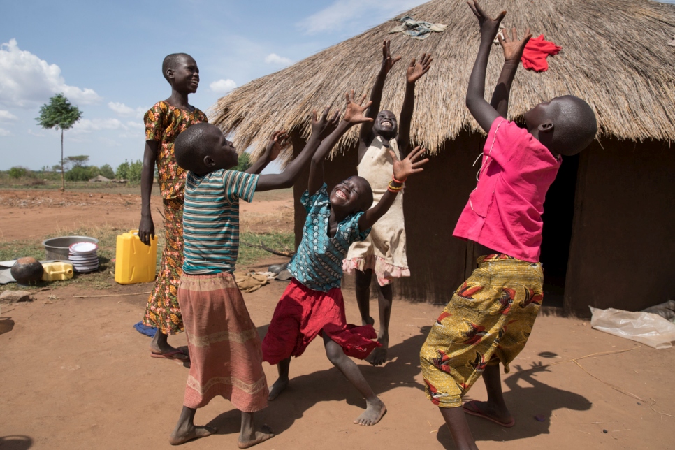 Las familias del campesino ugandés Yahaya Onduga y del refugiado sursudanés Mike Duke juegan juntas en el asentamiento de refugiados de Bidibidi. Mike, su esposa Kiden Mary y sus seis hijos llegaron a Bidibidi en septiembre de 2016.