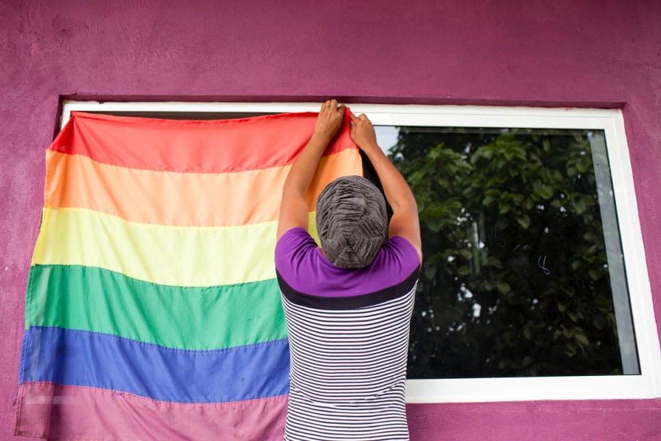 Una persona colgando una bandera LGBTIQ1 en México