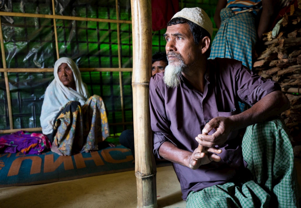 Oli Ahmed mira por la puerta del refugio de la familia bajo la mirada de su madre, Gul.  