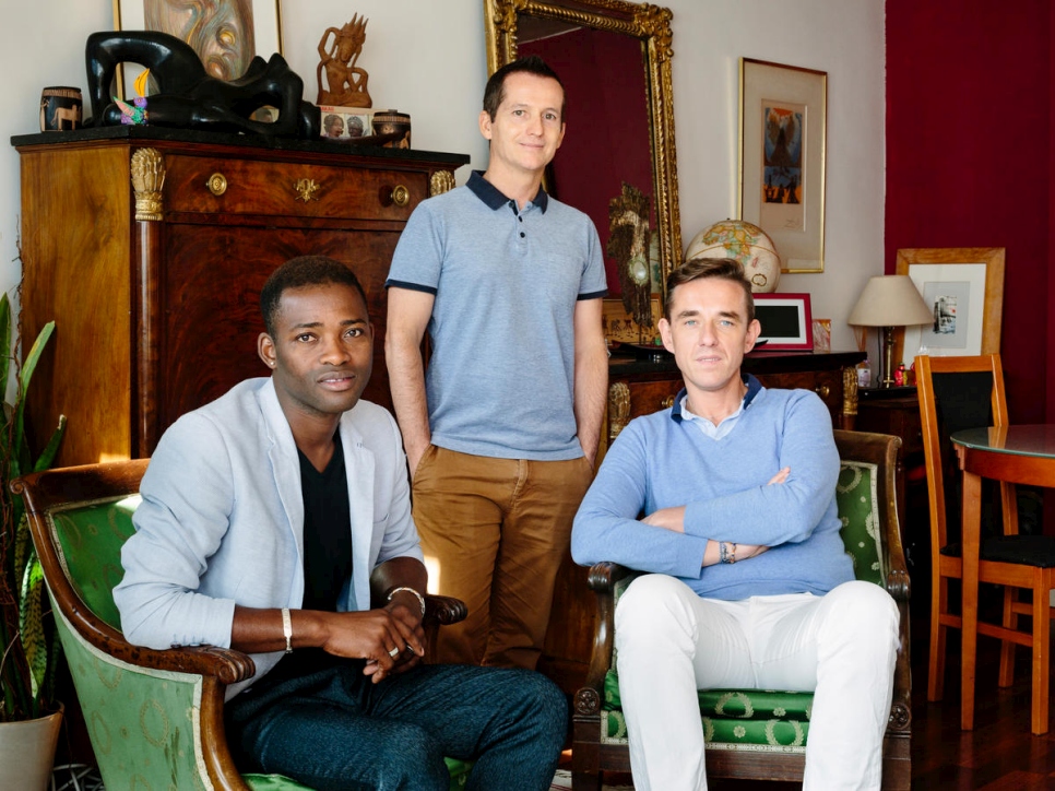 Christophe y Armand acogen a Louis (a la izquierda), refugiado de Malí, en el apartamento de una sola habitación en el que viven en París. Louis fue perseguido por su identidad sexual y sus actividades en la comunidad LGBT. 