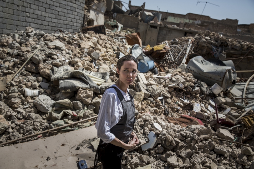 La Enviada Especial de ACNUR Angelina Jolie en la Ciudad Vieja en el oeste de Mosul durante su visita a Irak. Los residentes le comentaron que los cadáveres de muchos milicianos todavía están sepultados en los escombros detrás de ella. Las cobijas rojas señalan la presencia de artefactos sin explotar. 