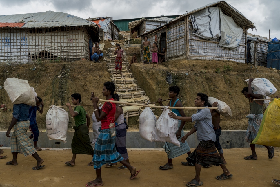 Los refugiados rohingya, que vivían en tiendas de campaña en riesgo de deslizamientos de tierra, llevan sus pertenencias mientras son reubicados en la nueva extensión de Camp 4, en el asentamiento de refugiados de Kutapalong en Bangladesh.  