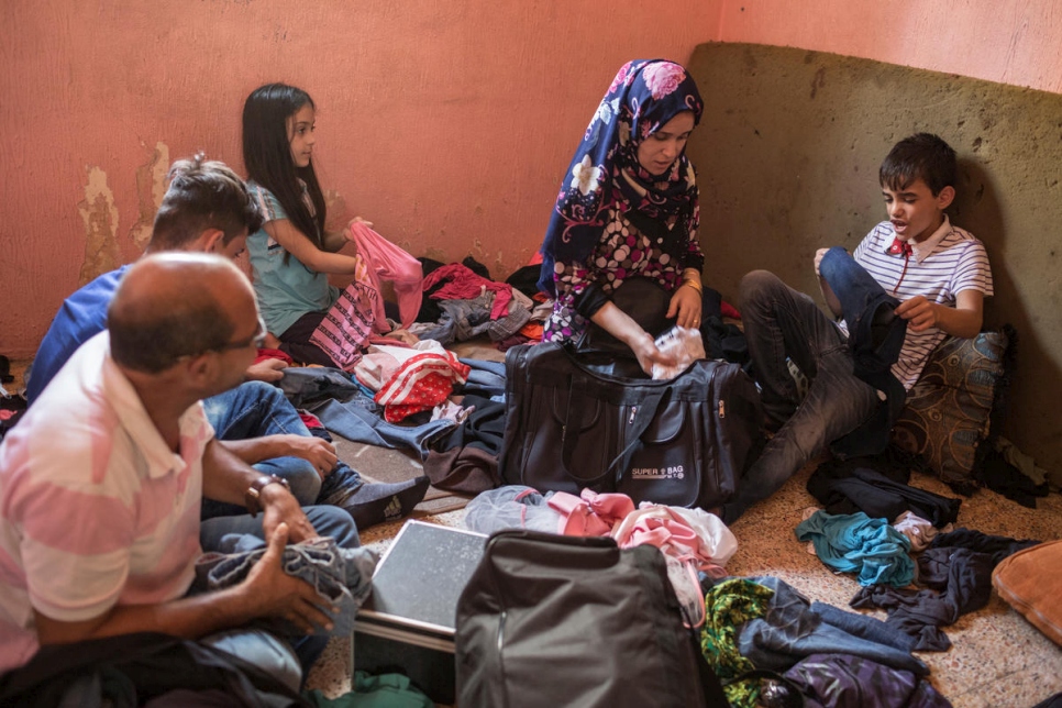 Zain, a la derecha, se sienta junto a su madre Nour, mientras la familia empaca para su traslado a Noruega. 