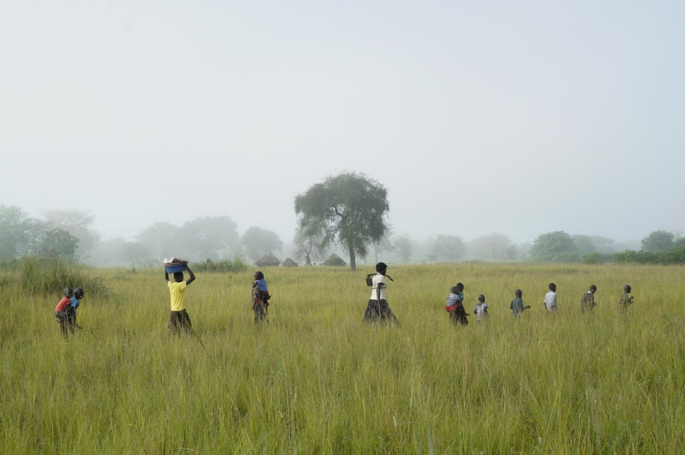 Los hijos y las hijas de Queen la ayudan en su finca en el asentamiento de Oliji, donde cultiva arroz.  