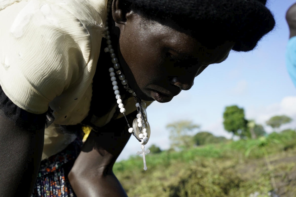 Queen, que huyó del conflicto en Sudán del Sur, atiende sus cultivos en Uganda.  