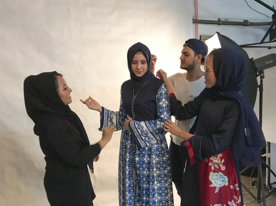 Franka Soeria (con pañuelo azul marino) ayuda a algunos de sus estudiantes refugiados con ajustes de último momento antes de una sesión de fotos en su taller de Markamarie en el sur de Yakarta.