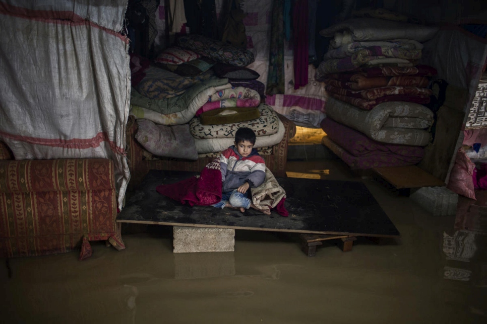 Uno de los hijos de Juriya Ramadan de sienta en la tienda inundada. Su tienda colapsó como consecuencia de la tormenta Norma. 