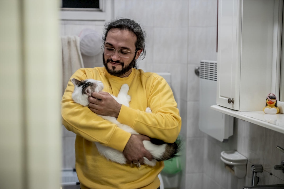 En su casa, en Belgrado, Mawaheb abraza a su gato, Fidel. Han estado juntos desde poco después de que Mawaheb huyera de la guerra en Siria. 