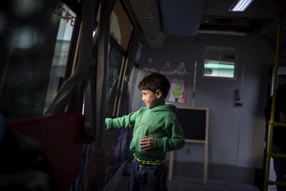 Ezzo, un refugiado sirio de 6 años de Alepo, mira por la ventana del "Fun Bus". 