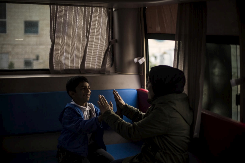 Un joven refugiado sirio juega con una de las voluntarias que trabajan en el autobús. 