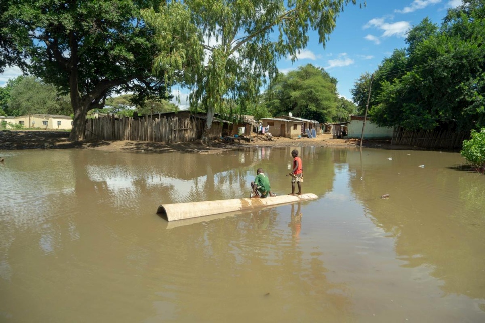 Dos niños se paran en medio de una gran piscina de agua que dejó el ciclón Idai, en el campamento de refugiados de Tongogara, Zimbabue. 