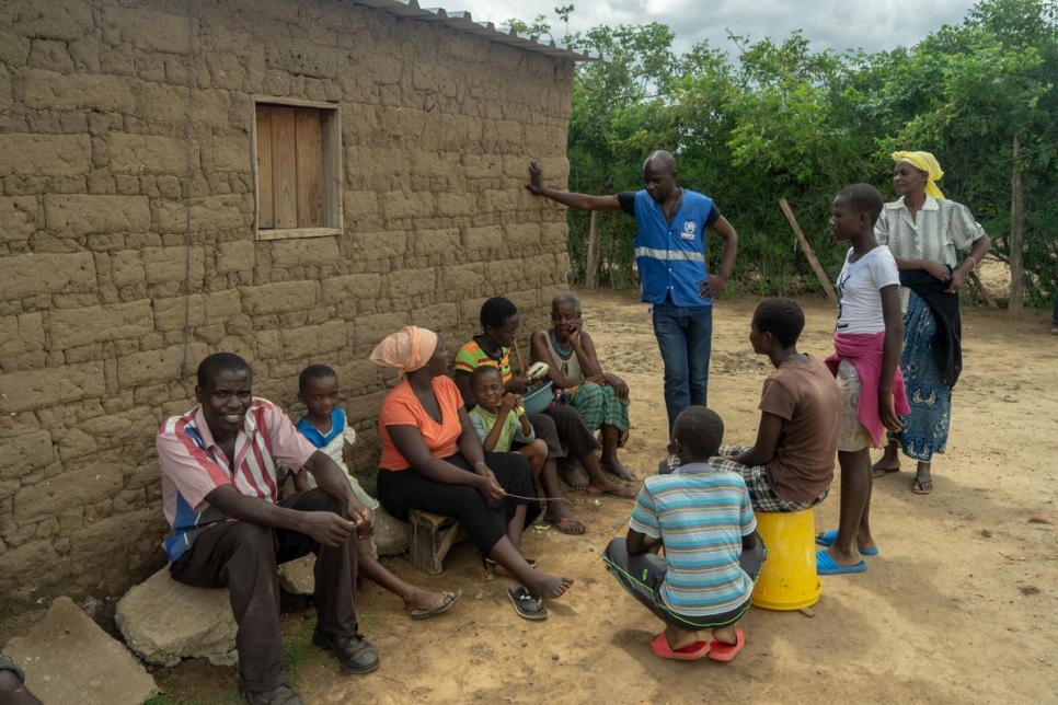 Un trabajador de ACNUR conversa con la familia de Magdalena Niragire en el campamento de refugiados de Tongogara, Zimbabwe. 