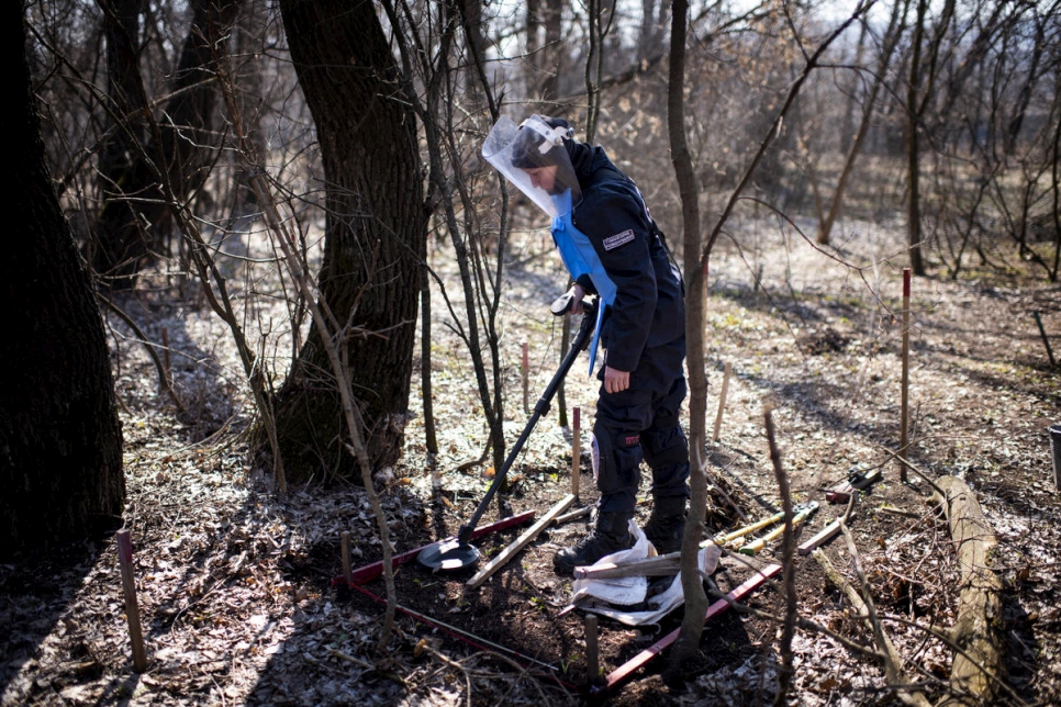 Tetiana usa un detector de metales para buscar minas terrestres en un bosque cerca de Ozerne, Donbas. 