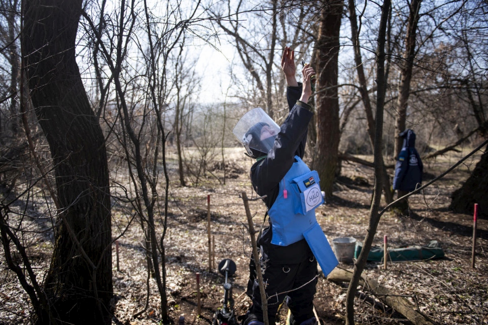 Tetiana corta ramas de árboles en su búsqueda de minas terrestres y alambres. 