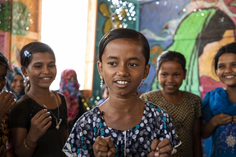 Myshara, refugiada rohingya de 13 años procedente de Myanmar, sentada con sus amigos en un programa de salud mental para niños y niñas en el campamento de Kutupalong (Bangladesh). "Me produce enorme felicidad poder ayudar a los demás", dice Myshara, que trabaja como voluntaria en el programa para ayudar a que los niños hablen sobre sus preocupaciones.