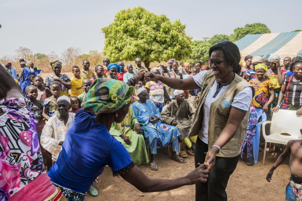 Rosine Zouassi, de la Asociación Femenina de Asistencia Jurídica de Côte d'Ivoire, baila con una residente de la aldea al término de una reunión informativa sobre documentación en Olleo, Côte d'Ivoire. 