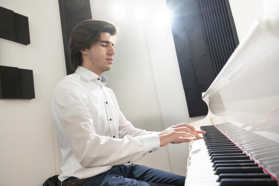 El pianista sirio autodidacta Hani Abo Harbbah Alnaeb, de 19 años, reserva un estudio de piano en Viena para prepararse de cara a un taller musical en el que estarán presentes el violonchelista Yo-Yo Ma y el Secretario General de las Naciones Unidas. Normalmente practica en casa por la noche con un teclado electrónico. 