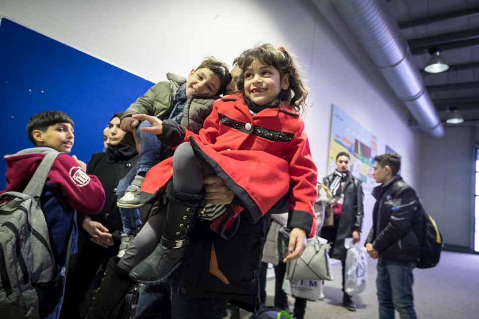 Un hombre sirio espera en la línea, junto a su hija e hijo, a que revisen sus pasaportes en el aeropuerto de Hanover, Alemania.