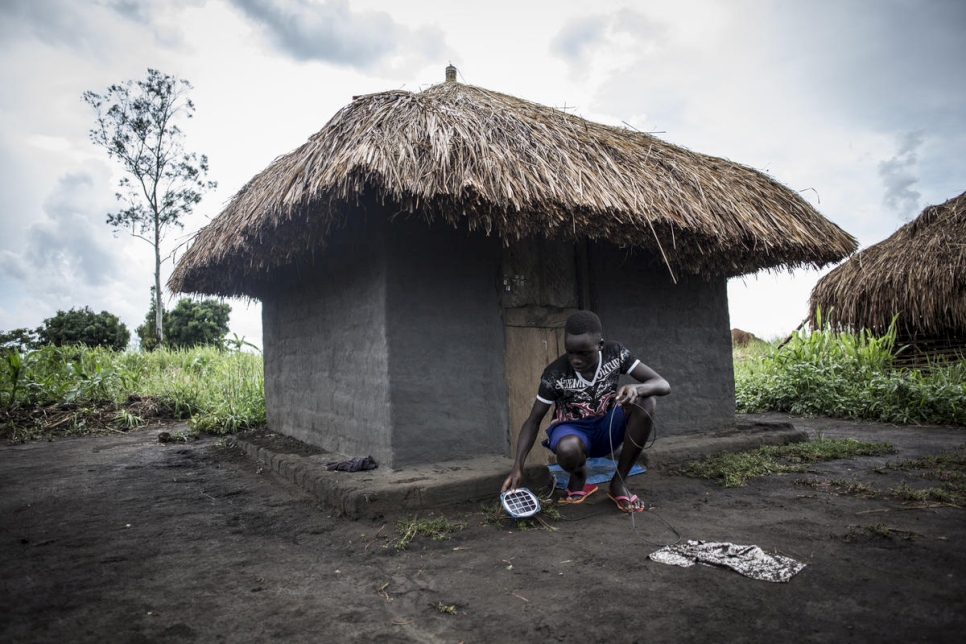 Gift, refugiado de Sudán del Sur de 14 años, carga su lámpara solar de fabricación propia para que pueda estudiar por la noche. Gift asiste a la escuela en el asentamiento de refugiados de Biringi en la República Democrática del Congo.