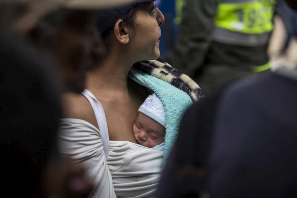 Una mujer hace fila cargando a su bebé en el comedor comunitario "La Divina Providencia", gestionado por la diócesis católica de Cúcuta, Colombia.