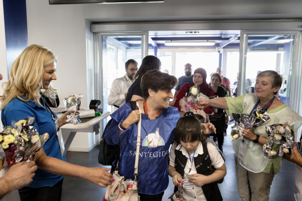 Maria Quinto, coordinadora de Corredores Humanitarios para la comunidad de Sant'Egidio, (centro) con Hebat, de nueve años, de Siria, justo después de aterrizar en Roma desde el Líbano. 