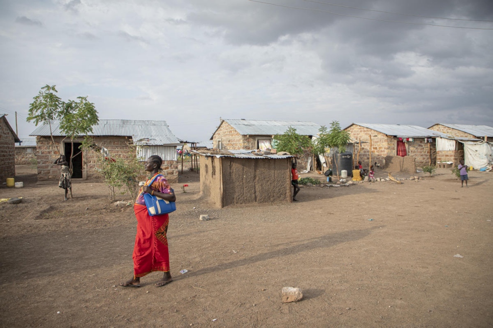 Florence Idiongo camina ante viviendas de nueva construcción en el asentamiento de Kalobeyei (Kenia).  