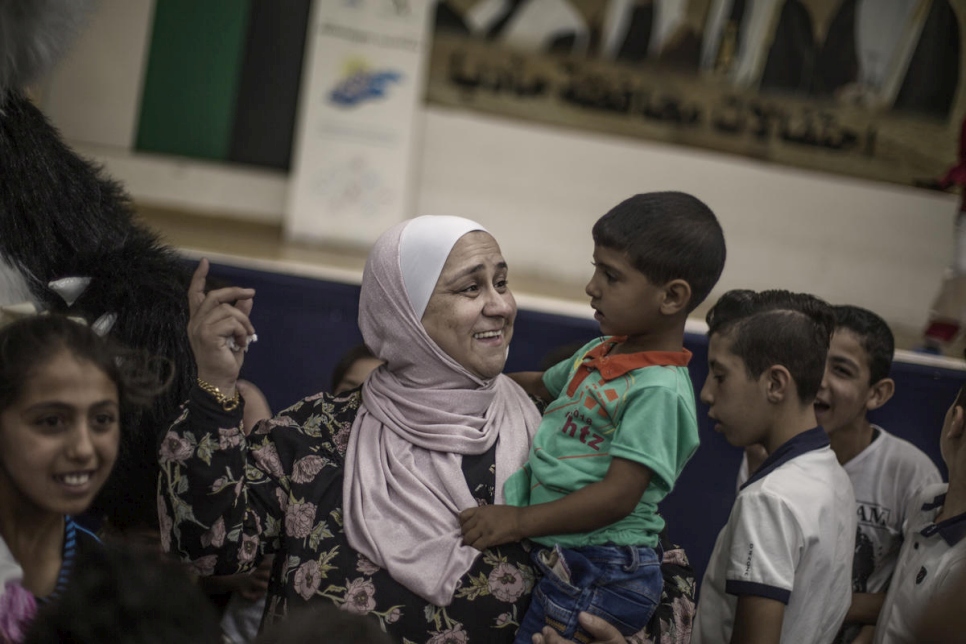 Abeer Khreisha juega con un niño refugiado sirio en un centro comunitario en Madaba, Jordania. 