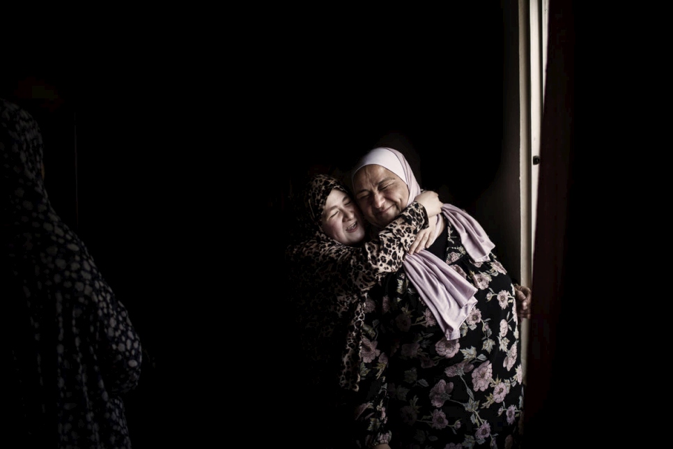 La hija de la refugiada siria Haifaa Al Dallal abraza a Abeer Khreisha mientras visita su casa en Madaba, Jordania 