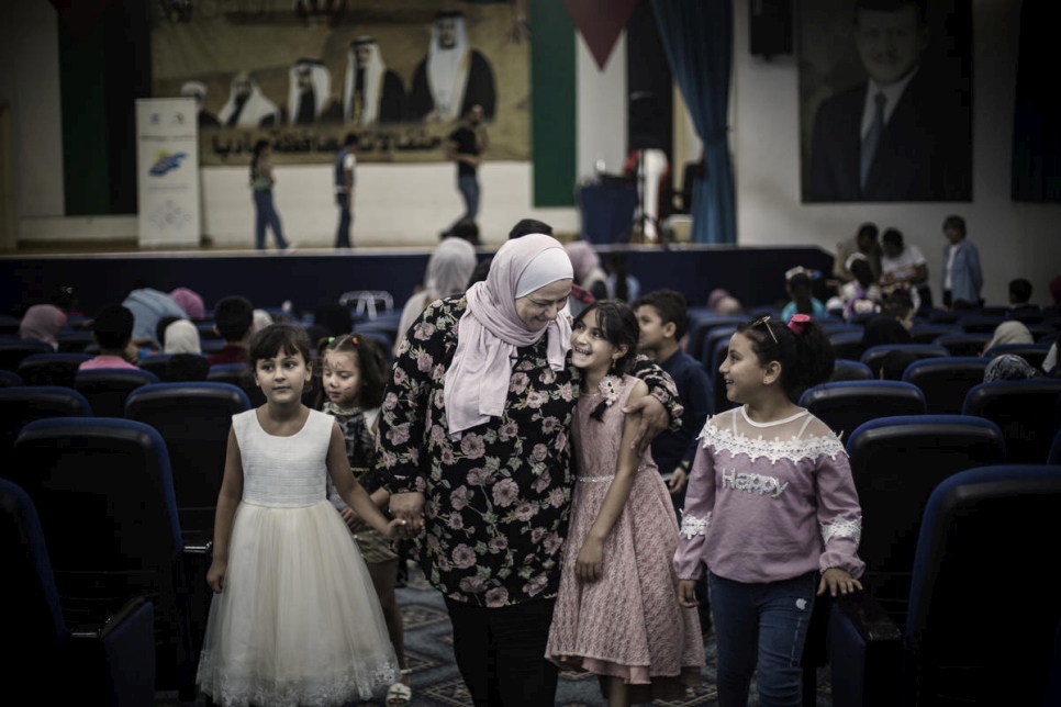 Abeer Khreisha está rodeado de jóvenes refugiados sirios durante un evento en un centro comunitario en Madaba, Jordania. 