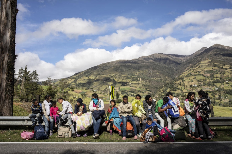 Una familia de 17 personas ha estado caminando durante cinco días. Aquí se ven tratando de calentarse al sol después de salir de su albergue temprano en la mañana para emprender el camino a Pamplona, Colombia. 