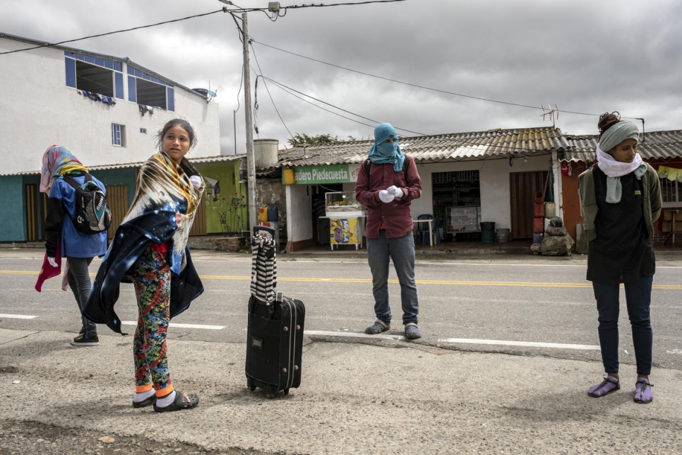 Los refugiados y migrantes venezolanos se ponen ropa abrigada en el pueblo de La Laguna antes de continuar su viaje por la carretera montañosa y llegar al paso de Berlín, que tiene más de 3.000 metros de altura. 