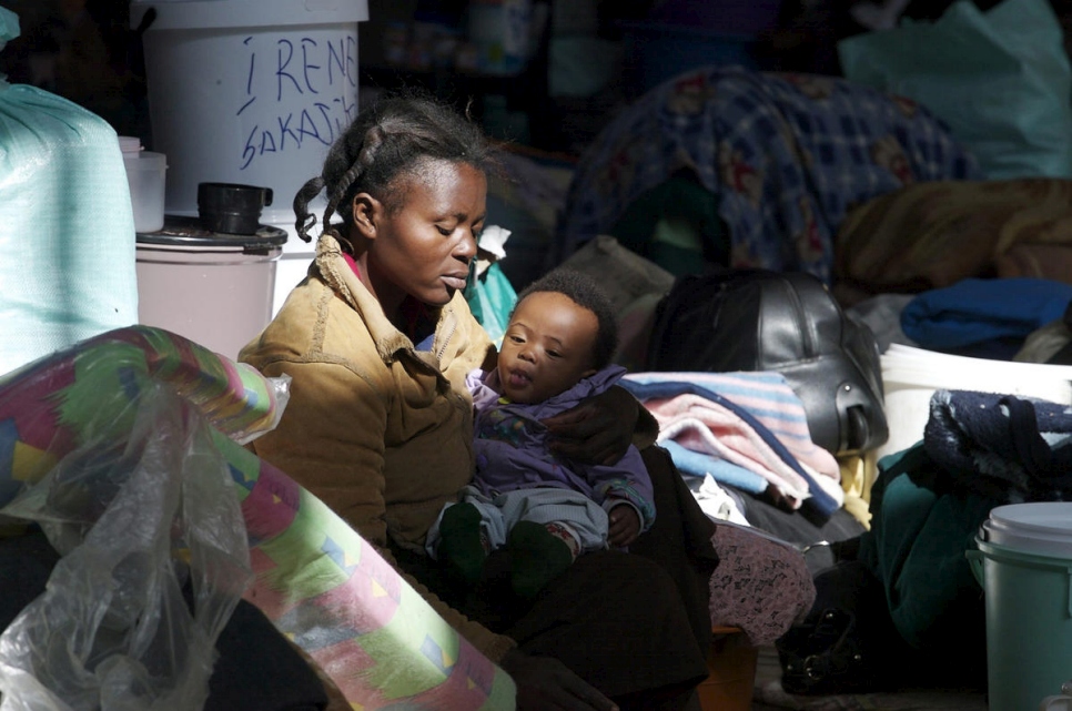 Una mujer con su hijo, desplazados por la violencia xenófoba, se refugian en un asentamiento improvisado en una comisaría en Johannesburgo, Sudáfrica, en junio de 2008.