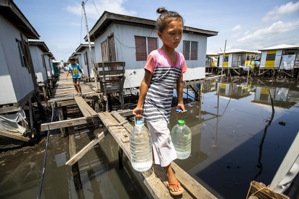 Una niña transporta agua en la comunidad de reasentamiento de Valle Vista, cerca de la ciudad de Zamboanga (Filipinas). La comunidad está compuesta por personas Sama Bajau y Tausug.