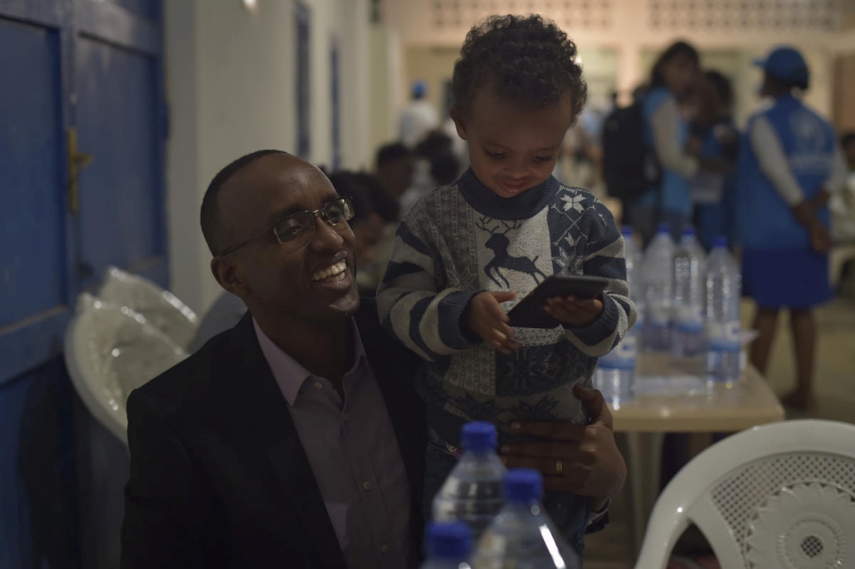 Richard Mutabazi, alcalde del distrito, juega con un pequeño en el Centro de Tránsito de Emergencia de Gashora (Rwanda). 