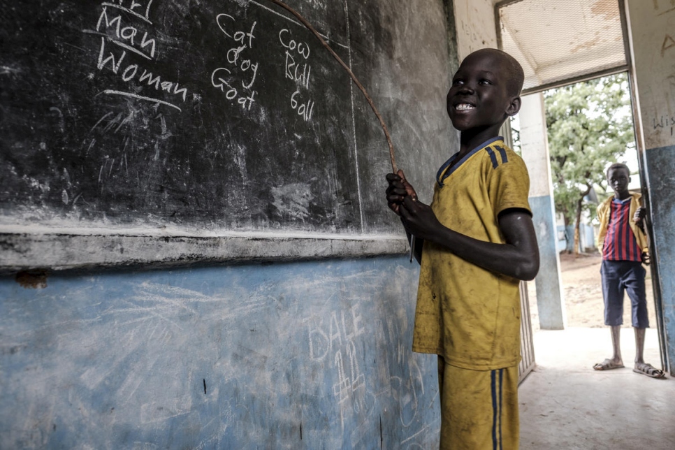 Un refugiado sursudanés sonríe mientras muestra lo que ha aprendido en la escuela primaria del campamento de refugiados de Jewi en Gambella, Etiopía. 